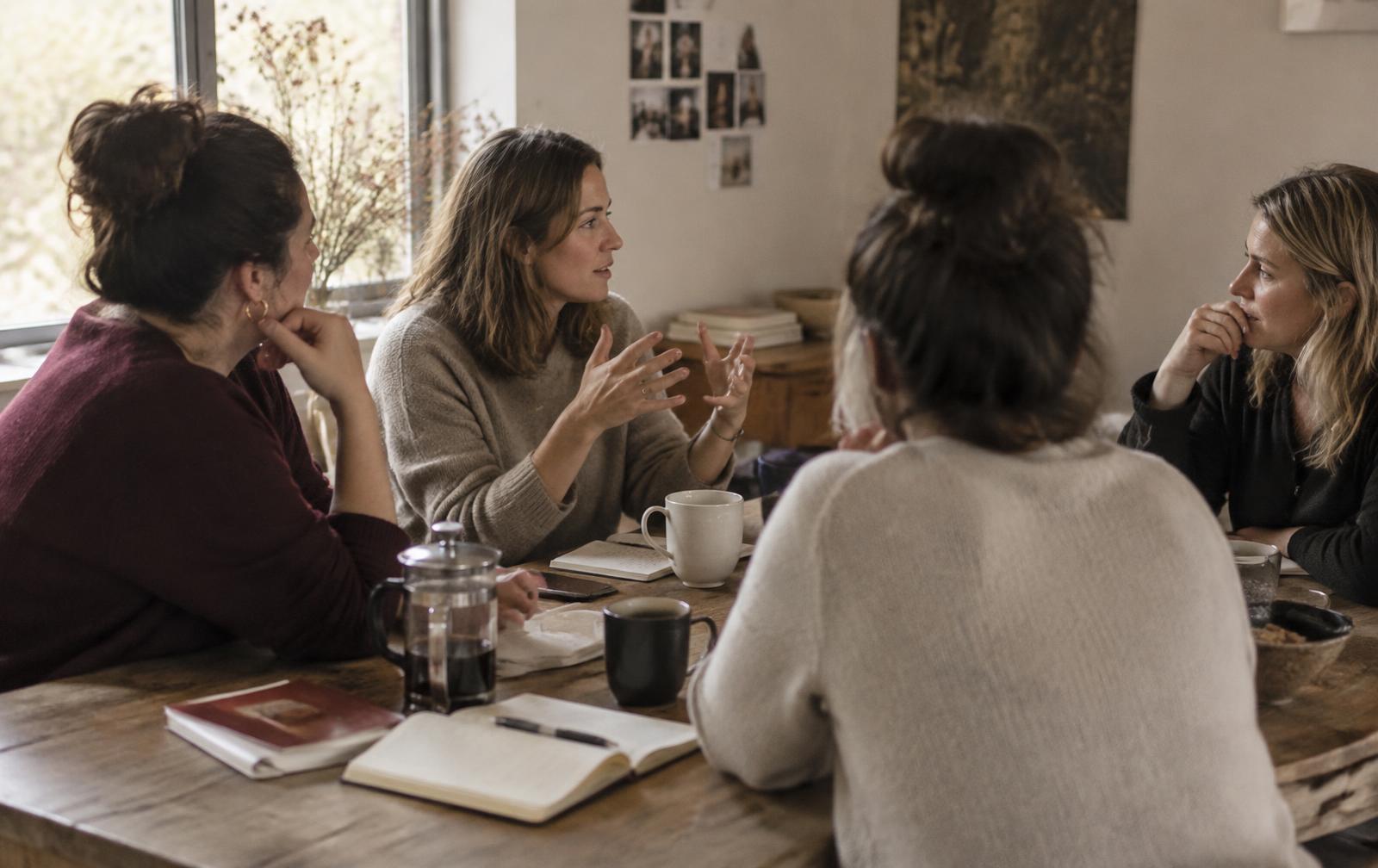 Mulheres conversando ao redor de uma mesa